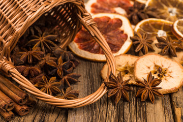 Star anise in a wicker basket on an old wooden table.