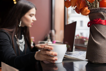 Beautiful brunette using laptop in cafe. coffee,