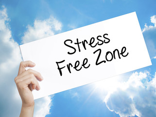Stress Free Zone Sign on white paper. Man Hand Holding Paper with text. Isolated on sky background