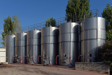 Stainless steel wine vats in a row inside the winery