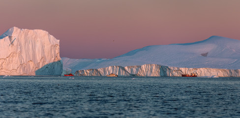 Huge icebergs and boat in the Gulf. Their source is by the Jakobshavn glacier. This is a...
