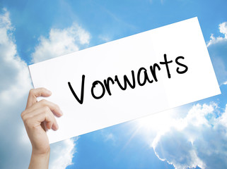 Vorwarts  (Forward In German)  Sign on white paper. Man Hand Holding Paper with text. Isolated on sky background