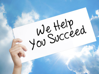 We Help You Succeed Sign on white paper. Man Hand Holding Paper with text. Isolated on sky background