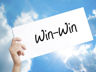 Win-Win  Sign on white paper. Man Hand Holding Paper with text. Isolated on sky background