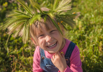 Little girl in the wreath of flowers and spikelets