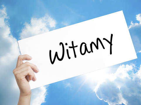 Witamy (Welcome in Polish) Sign on white paper. Man Hand Holding Paper with text. Isolated on sky background.