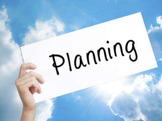 Planning Sign on white paper. Man Hand Holding Paper with text. Isolated on sky background