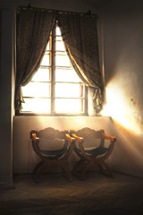 Vintage interior with armchairs and window in old castle