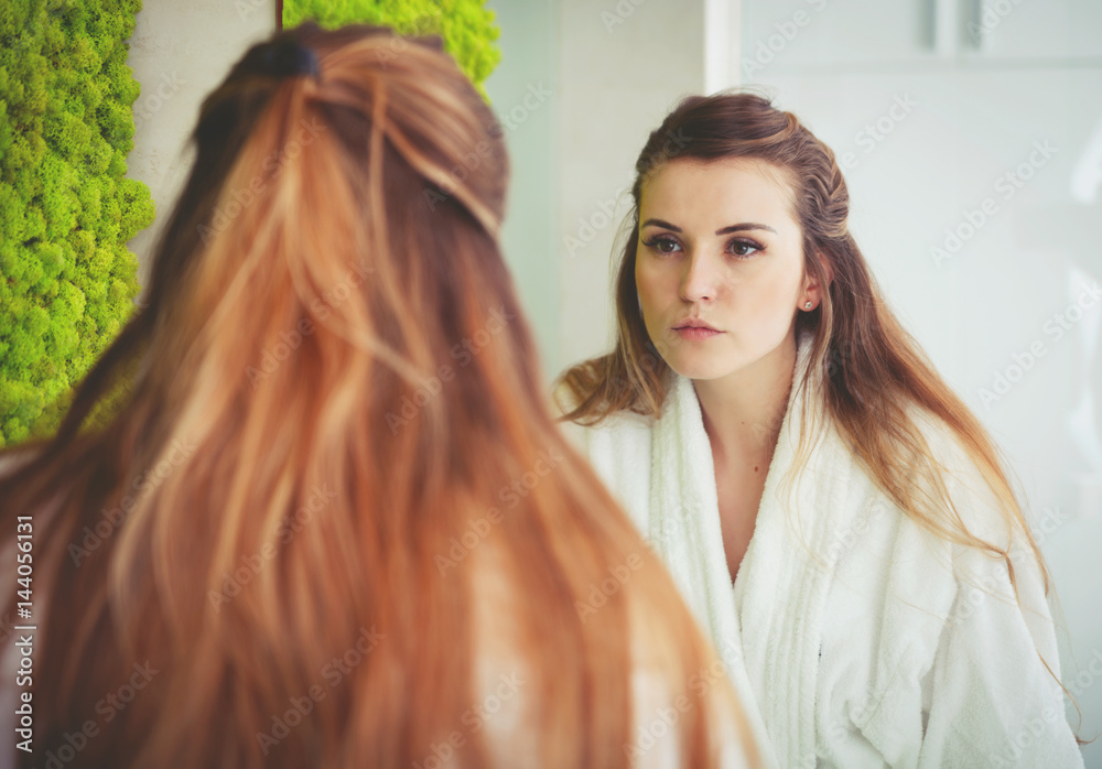 Sticker Pretty woman looking at mirror in modern bathroom