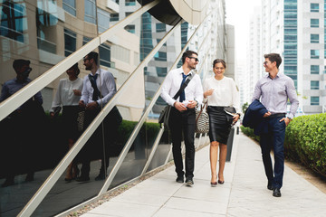 Group of business people walking talking.