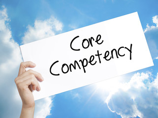 Core Competency Sign on white paper. Man Hand Holding Paper with text. Isolated on sky background