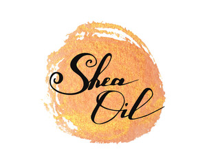 Hand written words Shea Oil on golden paint splash on white background