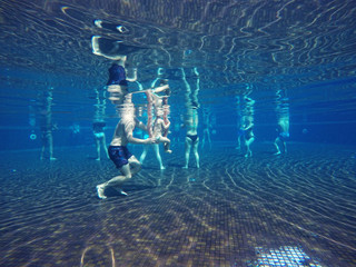 Subaquatic view of people practicing hydro gymnastics