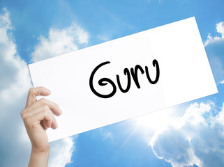 Guru Sign on white paper. Man Hand Holding Paper with text. Isolated on sky background