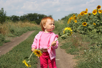 Beautiful red-haired child with sunflowers