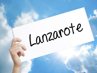 Lanzarote Sign on white paper. Man Hand Holding Paper with text. Isolated on sky background.