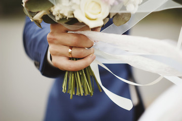 Beautiful Wedding bouquet and hand with wedding ring