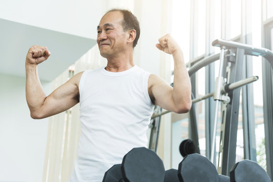 Asian Senior Man  Working Out At The Gym. Copy Space.