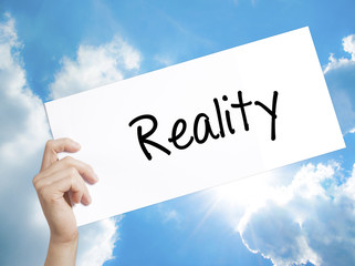  Reality Sign on white paper. Man Hand Holding Paper with text. Isolated on sky background