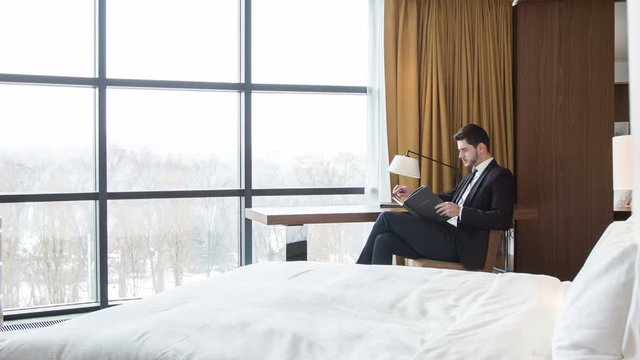 Serious businessman sitting in his hotel room