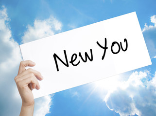 New You Sign on white paper. Man Hand Holding Paper with text. Isolated on sky background