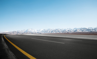 empty road with white snow mountains