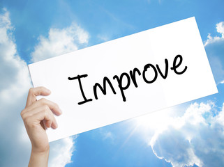 Improve Sign on white paper. Man Hand Holding Paper with text. Isolated on sky background