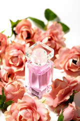 Perfume bottle in pink flower roses. Spring background with luxury aroma parfume. Beauty cosmetic...