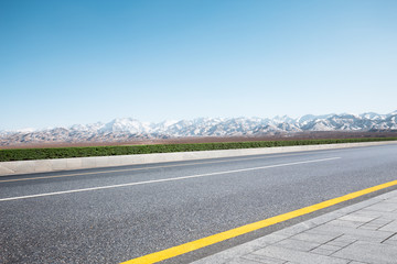 empty road with white snow mountains