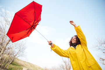 Woman catching flying umbrella
