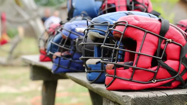 Red and blue protective helmets lies on the bench