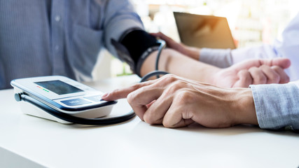 Fototapeta premium healthcare, hospital and medicine concept - doctor and patient measuring blood pressure
