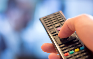 Fernbedienung vor Fernseher in Männerhand