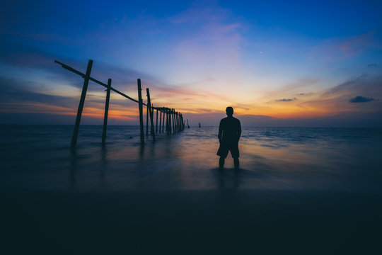 The silhouette of man standing alone at the beach, concept of lonely, sad, alone, person space, alone and scared