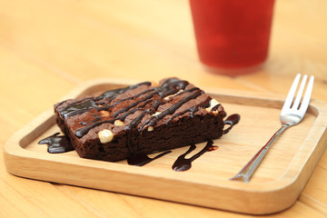 Homemade chocolate brownies on wooden plate.