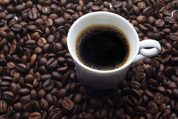 Cup and coffee over beans background