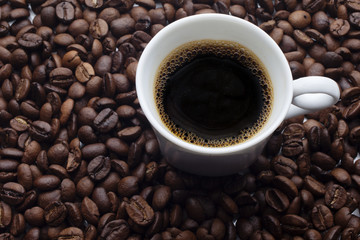 Cup and coffee over beans background