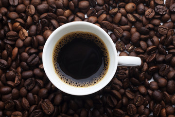 Cup and coffee over beans background