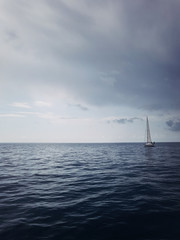 Yacht on the horizon in the blue sea