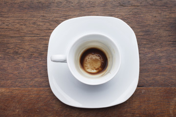 Cup of coffee with beans over wooden background