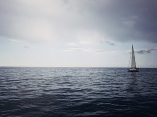 Obraz premium Yacht on the horizon in the blue sea