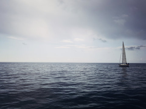 Yacht on the horizon in the blue sea