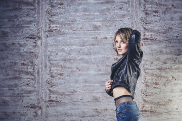 Beautiful woman model blonde sensual and fashionable at the background of metal wall