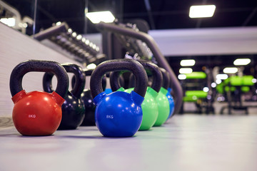 Naklejka na ściany i meble Sports kettlebell weights on floor in the gym.