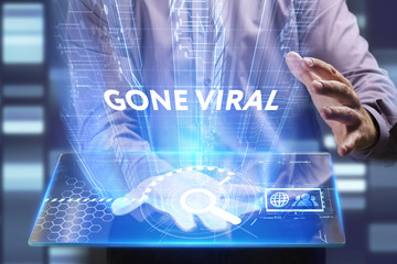 Business, Technology, Internet and network concept. Young businessman working on a virtual screen of the future and sees the inscription: Gone viral