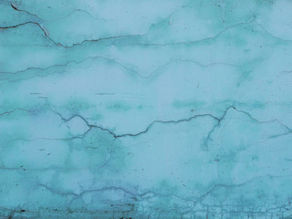 Abstract background of turquoise wall with cracks.