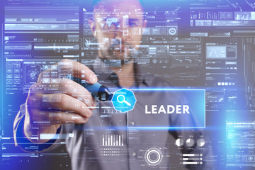 Business, Technology, Internet and network concept. Young businessman working on a virtual screen of the future and sees the inscription: Leader