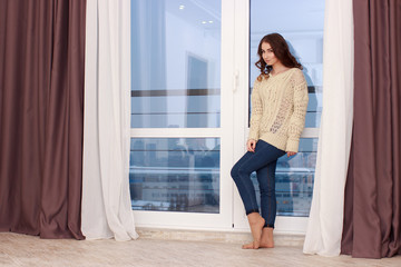 Fototapeta premium Girl Standing Near Window At Home
