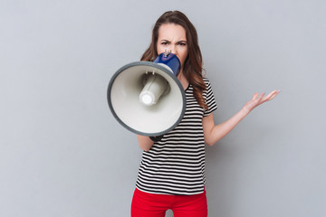 Screaming young pretty lady holding loudspeaker