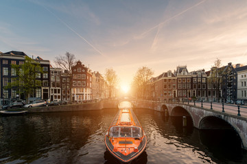 Amsterdamer Kanalkreuzfahrtschiff mit niederländischem traditionellem Haus in Amsterdam, Niederlande.
